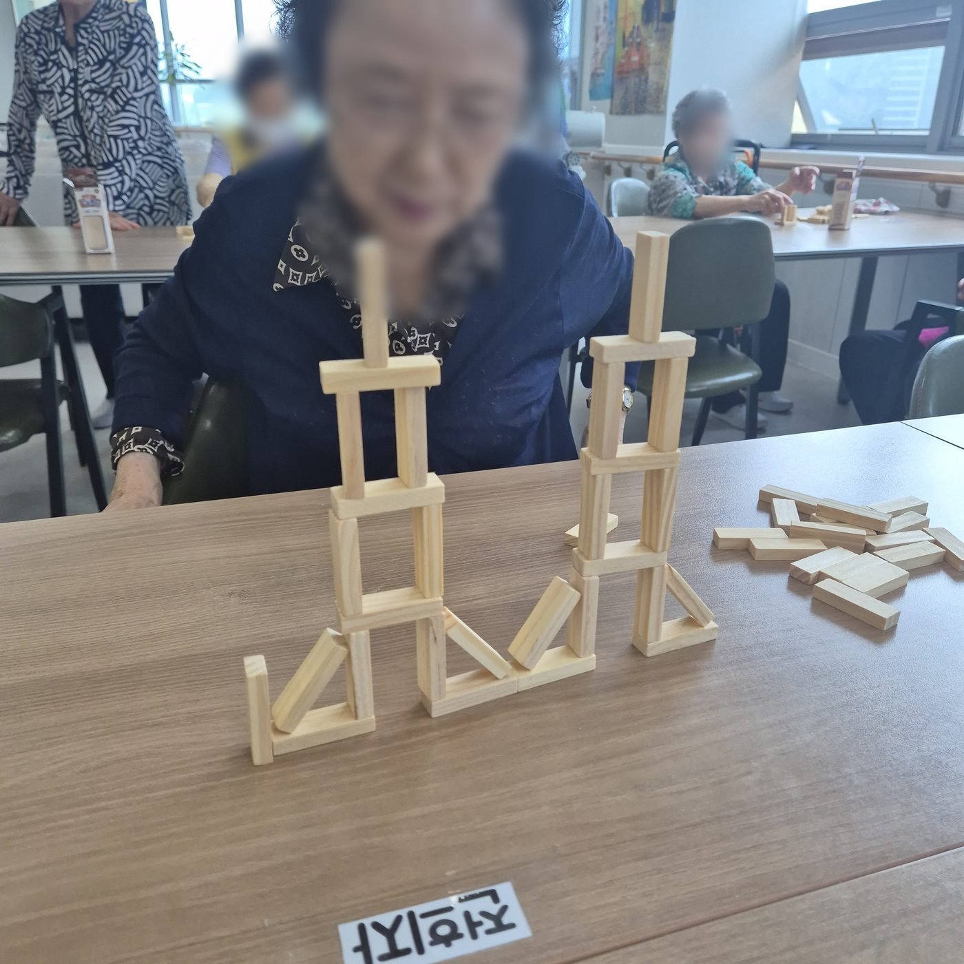 나무 블록으로 탑을 쌓는 어르신