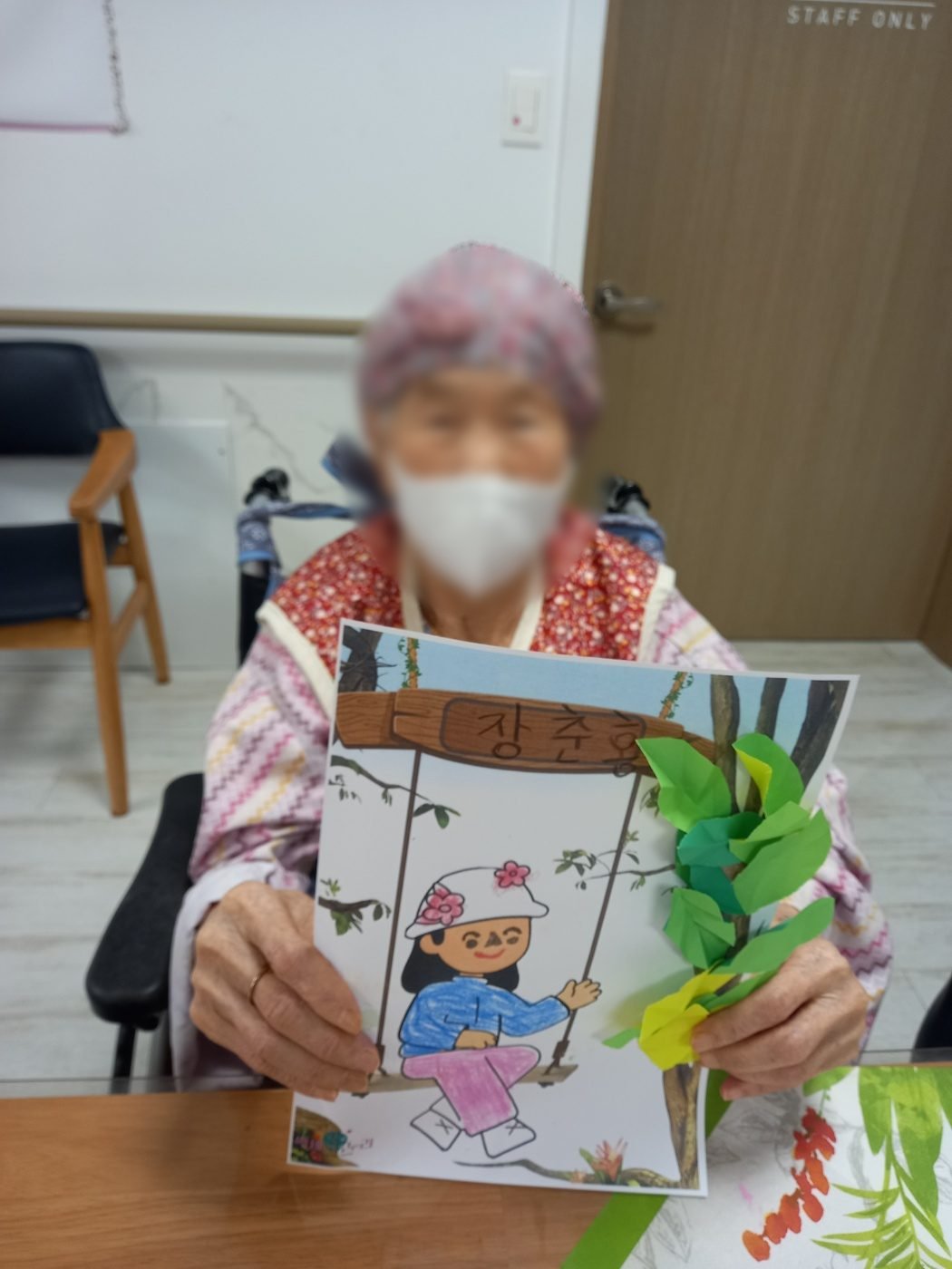 완성한 그림 카드를 들어 보이는 어르신