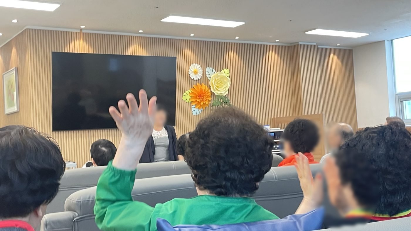 두 손을 들고 체조를 따라 하는 어르신들