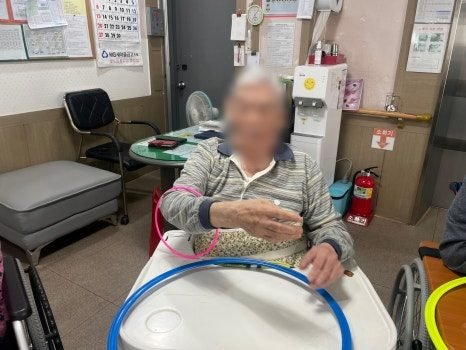 훌라후프 링을 잡고 운동하는 어르신